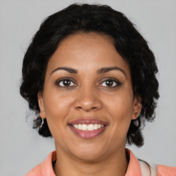 Joyful black adult female with medium  brown hair and brown eyes