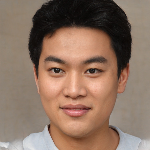 Joyful asian young-adult male with short  black hair and brown eyes