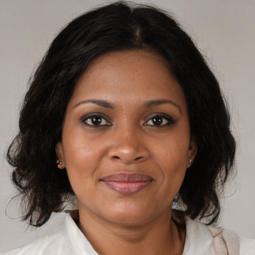 Joyful black adult female with medium  brown hair and brown eyes