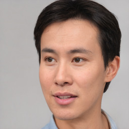 Joyful asian young-adult male with short  brown hair and brown eyes