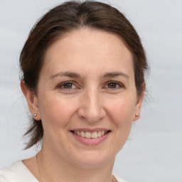 Joyful white adult female with medium  brown hair and brown eyes