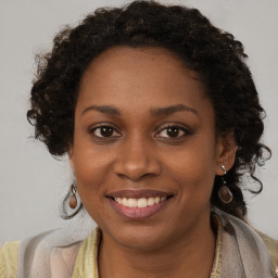 Joyful black young-adult female with long  brown hair and brown eyes