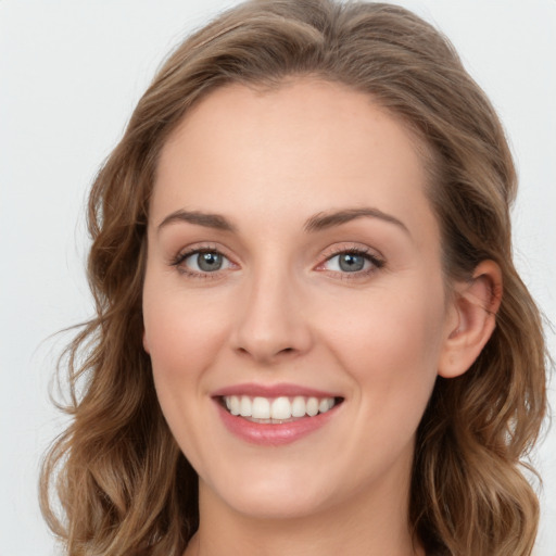 Joyful white young-adult female with long  brown hair and green eyes