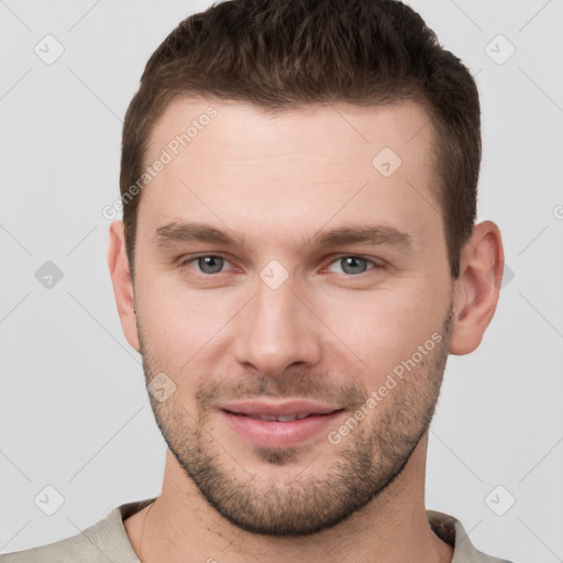 Joyful white young-adult male with short  brown hair and grey eyes