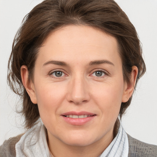 Joyful white young-adult female with medium  brown hair and grey eyes