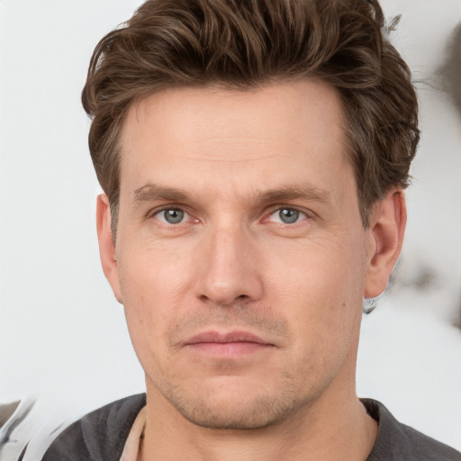 Joyful white adult male with short  brown hair and grey eyes