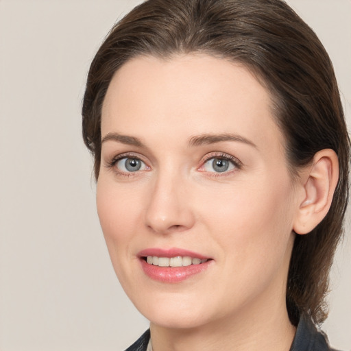 Joyful white young-adult female with medium  brown hair and grey eyes