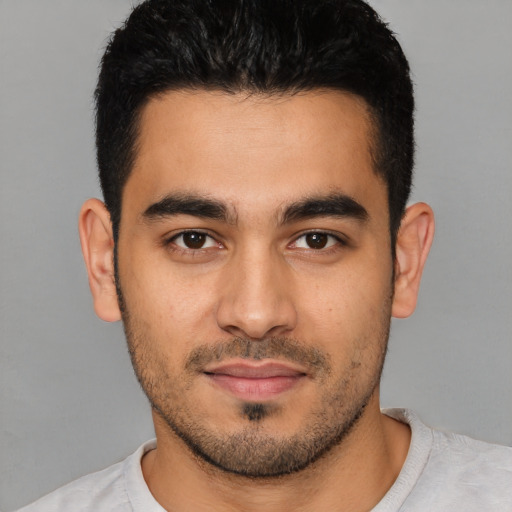 Joyful latino young-adult male with short  black hair and brown eyes