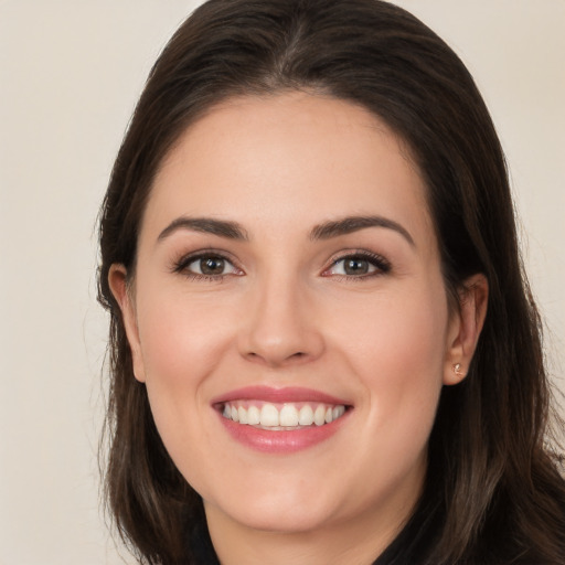 Joyful white young-adult female with long  brown hair and brown eyes