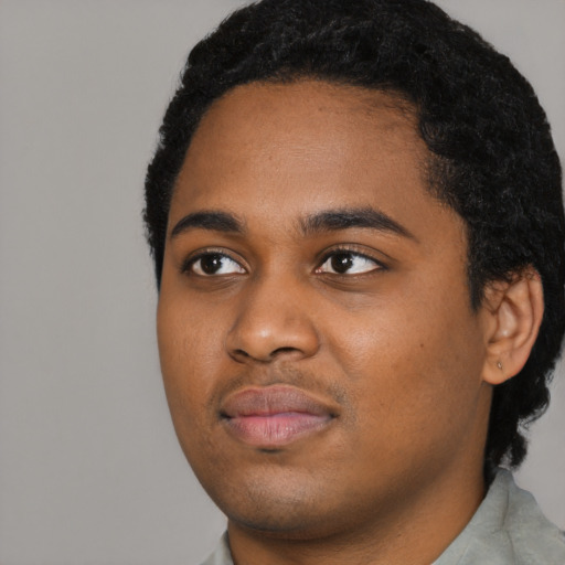 Joyful black young-adult male with short  black hair and brown eyes