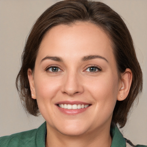 Joyful white young-adult female with medium  brown hair and green eyes