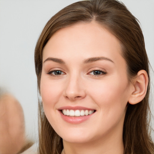 Joyful white young-adult female with long  brown hair and brown eyes