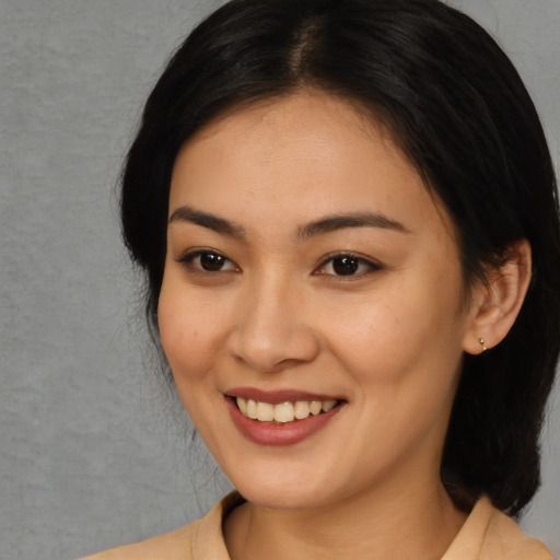 Joyful asian young-adult female with medium  black hair and brown eyes