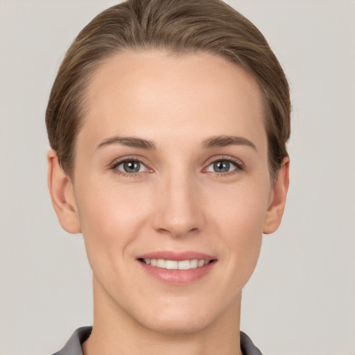 Joyful white young-adult female with short  brown hair and grey eyes