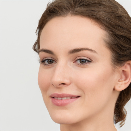 Joyful white young-adult female with medium  brown hair and green eyes