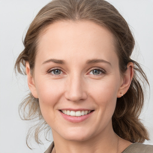 Joyful white young-adult female with medium  brown hair and grey eyes