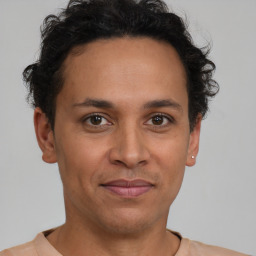 Joyful latino adult male with short  black hair and brown eyes