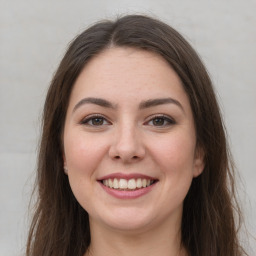 Joyful white young-adult female with long  brown hair and grey eyes