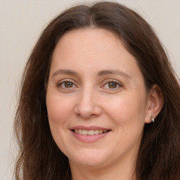 Joyful white adult female with long  brown hair and grey eyes