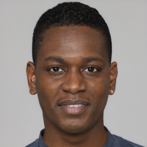 Joyful black young-adult male with short  black hair and brown eyes
