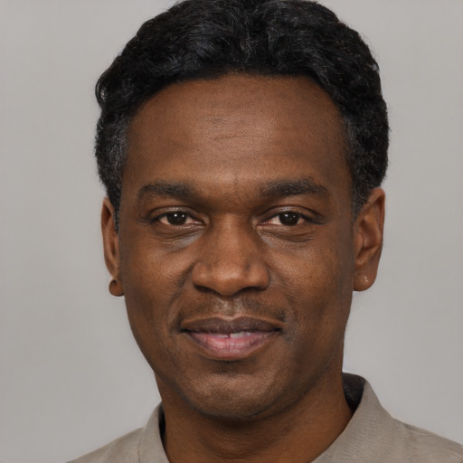 Joyful black young-adult male with short  black hair and brown eyes