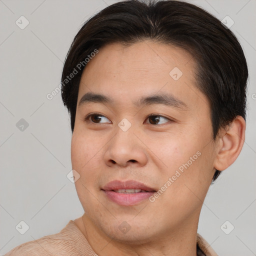 Joyful asian young-adult male with short  brown hair and brown eyes