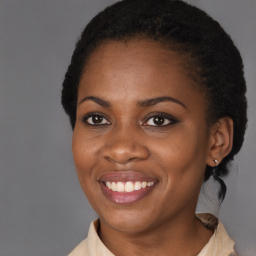 Joyful black young-adult female with short  black hair and brown eyes