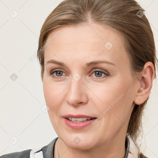 Joyful white adult female with medium  brown hair and grey eyes