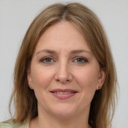 Joyful white adult female with medium  brown hair and grey eyes