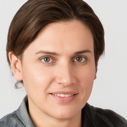 Joyful white young-adult female with medium  brown hair and grey eyes