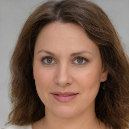 Joyful white young-adult female with medium  brown hair and green eyes