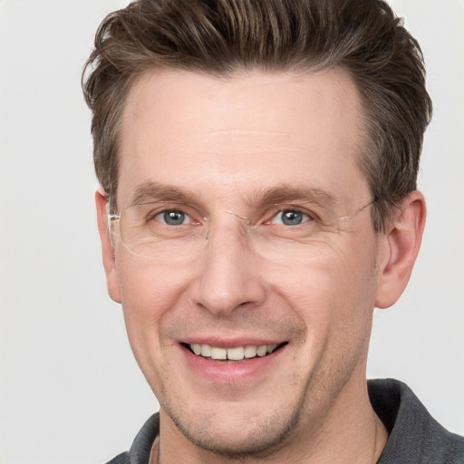 Joyful white adult male with short  brown hair and grey eyes