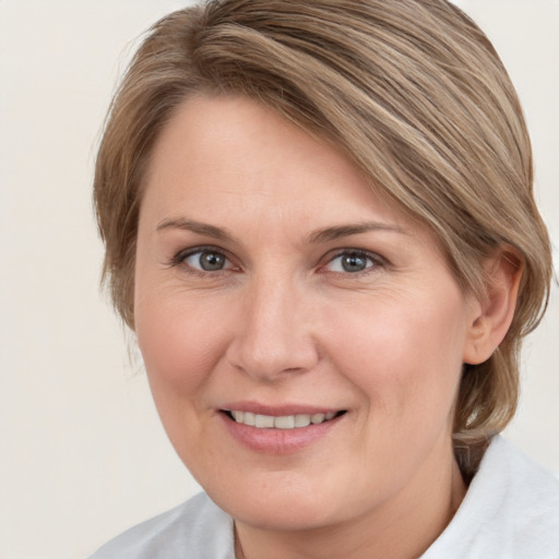 Joyful white adult female with medium  brown hair and grey eyes