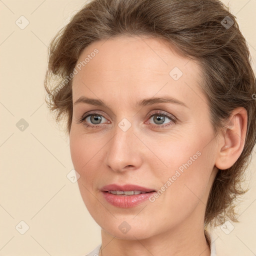 Joyful white young-adult female with medium  brown hair and green eyes