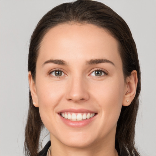 Joyful white young-adult female with long  brown hair and brown eyes