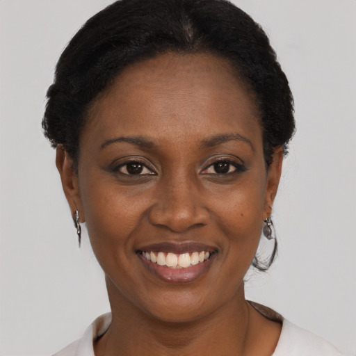 Joyful black young-adult female with short  black hair and brown eyes