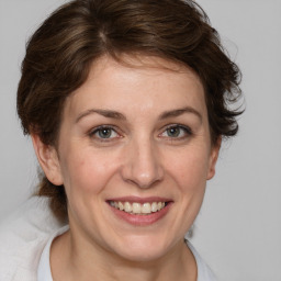 Joyful white young-adult female with medium  brown hair and blue eyes