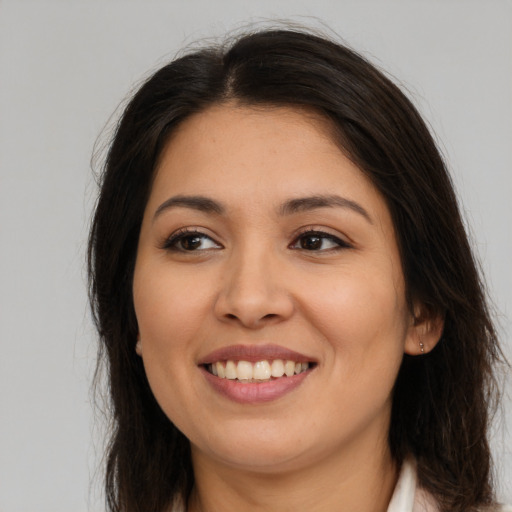 Joyful latino young-adult female with long  brown hair and brown eyes