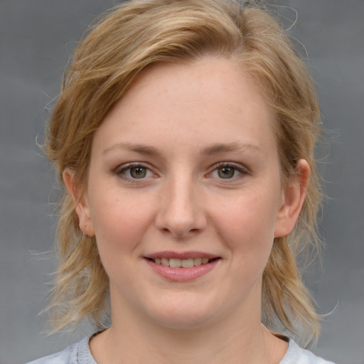 Joyful white young-adult female with medium  brown hair and blue eyes