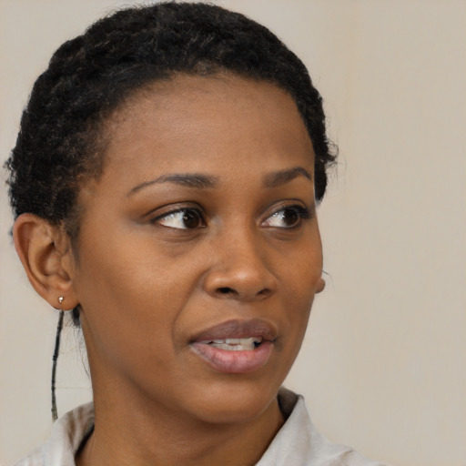 Joyful black young-adult female with short  brown hair and brown eyes