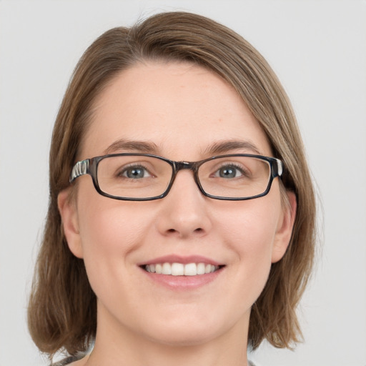 Joyful white young-adult female with medium  brown hair and green eyes