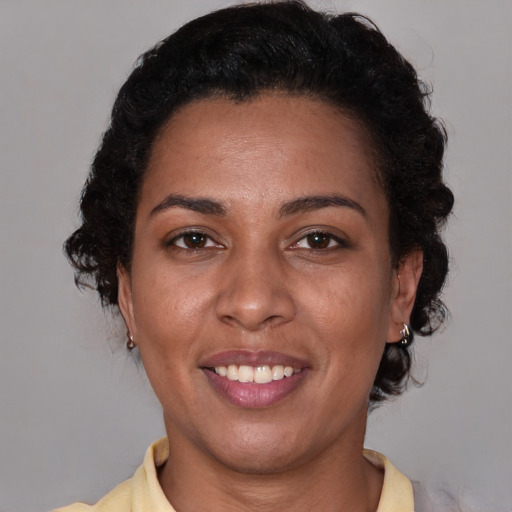 Joyful latino adult female with medium  brown hair and brown eyes