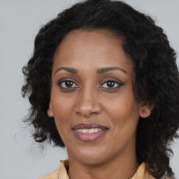 Joyful black adult female with long  brown hair and brown eyes