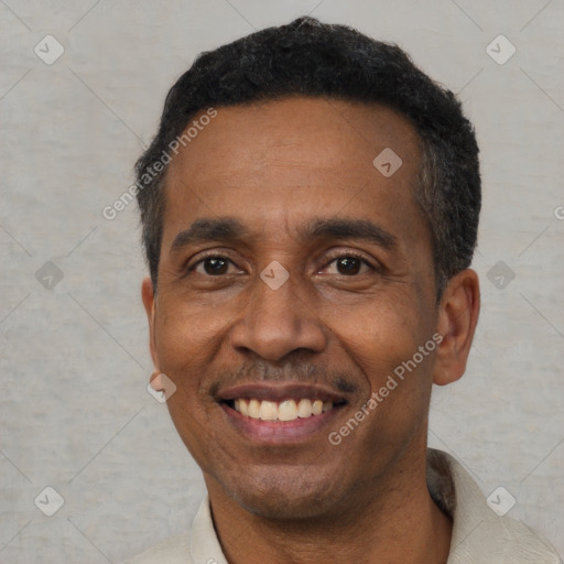 Joyful black adult male with short  black hair and brown eyes