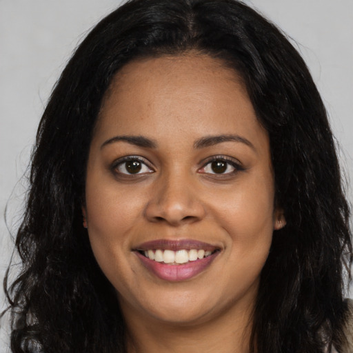 Joyful black young-adult female with long  brown hair and brown eyes