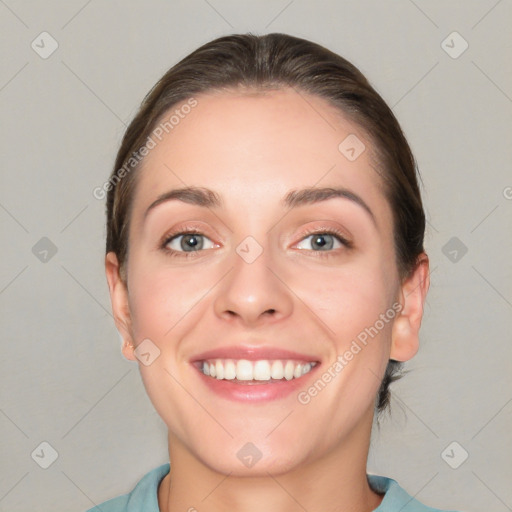 Joyful white young-adult female with short  brown hair and grey eyes