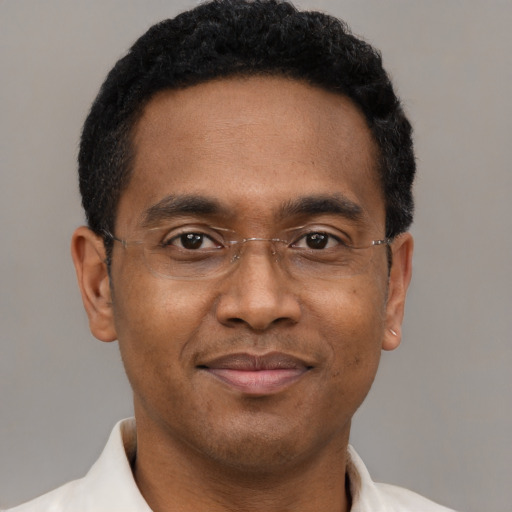 Joyful black adult male with short  brown hair and brown eyes