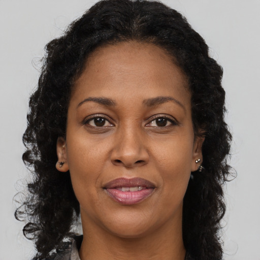 Joyful black adult female with long  brown hair and brown eyes