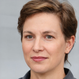 Joyful white adult female with medium  brown hair and grey eyes