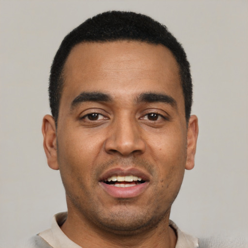 Joyful latino young-adult male with short  black hair and brown eyes